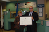 USCIS Director Emilio T. González presents Anna Prager with the "Outstanding American by Choice" recognition in Providence, RI, Nov. 1, 2007