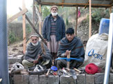 Following the October 2005 earthquake, Pakistani beneficiaries display reconstruction kits provided by USAID through CRS.
