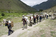Beneficiaries carry supplies provided through an OFDA-supported drought assistance program in Nepal.