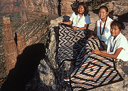 Three navaho women displaying their weaving