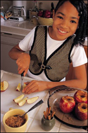 A young girl slicing fruit
