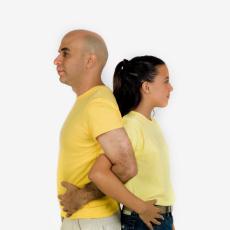 Fotografía de un hombre y una niña dándose la espalda con los brazos enlazados
