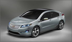 Photo of the Chevy Volt, a four-door sedan with a steeply raked windshield that blends into a black roof, which continues to the car's tail end. The car has narrow, squinty headlights, unusual L-shaped fog and turn lights in front, and a closed grill.