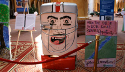 Photo of a refrigerator on display at the Art of Recycling: The Coolest Show in Town exhibit.  The refrigerator has been decorated to resemble a football player's head.