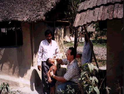 housing in background with men surrounding child