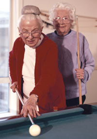 Two older women playing biliards.