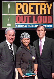 Young African-American student holding a small glass pyramid award, standing between John barr on the left and Dana Gioia on the right