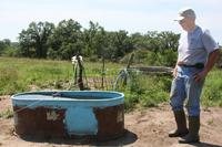 Bedford farmer Paul Ackley checks cattle watering tanks that are part of a new rotational grazing system NRCS designed for his farm.  (NRCS image -- click to enlarge)