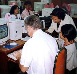 Students and teacher working on desktop computers.