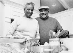 Photo of a mature couple outdoors at a barbeque.