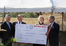 Director of Legislative and Intergovernmental Affairs Patty Sheetz and U.S. Senator James Inhofe join local officials in holding $1 million check. Click here for larger image.