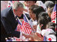 President George W. Bush pauses to greet school children Wednesday, Aug. 6, 2008, during arrival ceremonies at the Blue House, the residence of President Myung-bak Lee of the Republic of Korea, in Seoul. White House photo by Chris Greenberg
