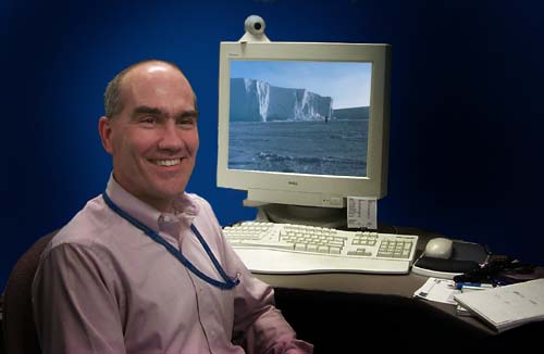 Picture of Michael Van Woert sitting at a PC overlaid with a picture of him taken in the Antarctic.