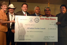 Assistant Secretary Benjamin Erulkar holding check with Congressional Representative Heather Wilson and Members of the All Indian Pueblo Council.
