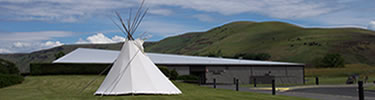 A white canvas tipi in front of the Spalding Visitor Center, Spalding Idaho. This is the primary visitor center for the park.