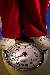 Legs and feet of a person standing on a weight scale. Link to photo information