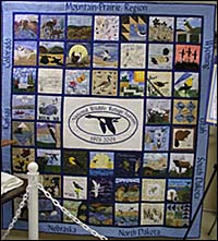 A colorful patchwork quilt with a blue goose in the center, the representative image for the National Wildlife Refuge System.
