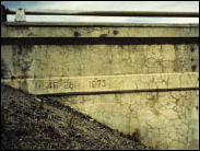 Figure 6. Photo. Surface Discoloration Caused in a Bridge Structure Caused by ASR. This photo shows the side of a bridge structure with extensive horizontal and vertical cracking and surface discoloration.