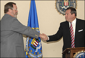 Photograph: Terry Lane (left) accepts the award from Jacksonville, Florida, Assistant Special Agent in Charge Nestor Duarte.