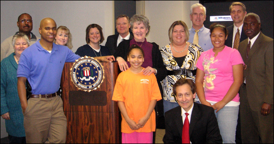 Carlie Shockey (front row, middle), along with her mom and sister (second, second and third from right), during her recent visit with some of the Kansas City employees who worked on her kidnapping case 10 years ago.