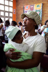 Photo of an HIV-positive woman holding her baby and singing at the Perinatal HIV Research Unit clinic at the Chris Hani Baragwanath Hospital in Soweto, South Africa.