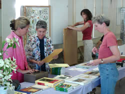 four women preparing publications and displays for a wildflower show.