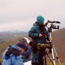 Biologists use a spotting scope to study sheep across the valley.