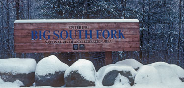 Park entrance sign under winter snows.
