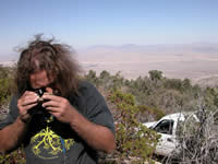 lichenologist using a hand lens to identify a lichen.