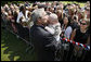 President George W. Bush gives a kiss to a baby during his greeting with members of the U.S. Mission in France, Saturday, June 14, 2008, at the Ambassador's residence in Paris. White House photo by Eric Draper