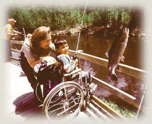 A kid in a wheelchair reeling in a big one. 