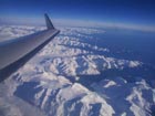 Aircraft Wing over Snow Covered Mountains