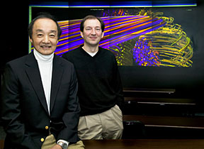 PPPL Chief Scientist Bill Tang (left) and PPPL computational scientist Stephane Ethier are at the Lab’s High-Resolution Wall. In the background is a plasma turbulence simulation.