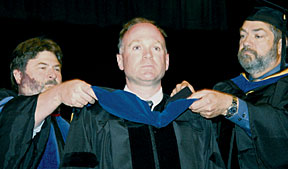 Chris Cross receives his Ph.D. hood from Department Chair James Luscombe and LLNL Chair Professor Craig Smith .