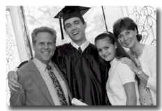 boy in cap and gown with his family