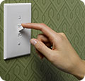 A woman turning off a light switch.