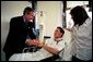 President George W. Bush shakes hands with Army SFC Thomas Douglas of Fayetteville, N.C., after presenting him with the Purple Heart at Walter Reed Army Medical Center in Washington, D.C., Friday, April 11, 2003. Also pictured is Mr. Douglas' wife, Donna Douglas.  White House photo by Eric Draper