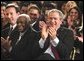 President George W. Bush applauds during the Celebration of Hispanic Heritage Month in the East Room, Thursday, Oct 2, 2003. Also pictured from left are, Tony Garza, U.S. Ambassador to Mexico and Pedro Knight, the husband of late singer Celia Cruz.  White House photo by Eric Draper