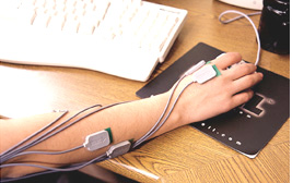 an arm using a computer mouse and wearing the MyoMonitor