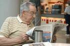 Photo of a man reading a newspaper. - Click to enlarge in new window.