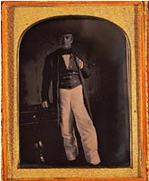 John Ross, full length portrait, facing front standing next to a small table