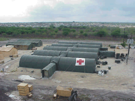 Photo of an emergency medical facility constructed from a series of long, barracks-like tents.