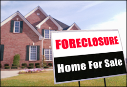 Photo of a home with a sign in the front reading; Foreclosure, Home For Sale.
