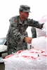 A Mississippi Army National Guardsman grabs bags of ice for a needy resident, Sept. 2, 2008, at a distribution point just outside Gulfport, Miss. Mississippi Army National Guardsmen provided nearly 1,000 returning Hurricane Gustav evacuees with bottled water and ice.