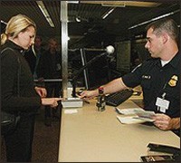 A  CBP officer takes a passenger's fingerprint scan to compare with the IAFIS database.