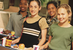 Picture of four school-age children holding lunch trays.