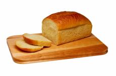 Photograph of a loaf of white bread on a cutting board