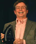 Jim Fruchterman holding an award and smiling