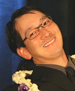 Brian Kajiyama, with a lei around his neck, smiling