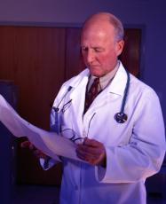 Photograph of a male doctor looking at a chart